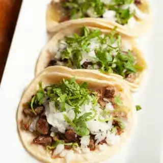 Tacos de Calle topped with onion and cilantro